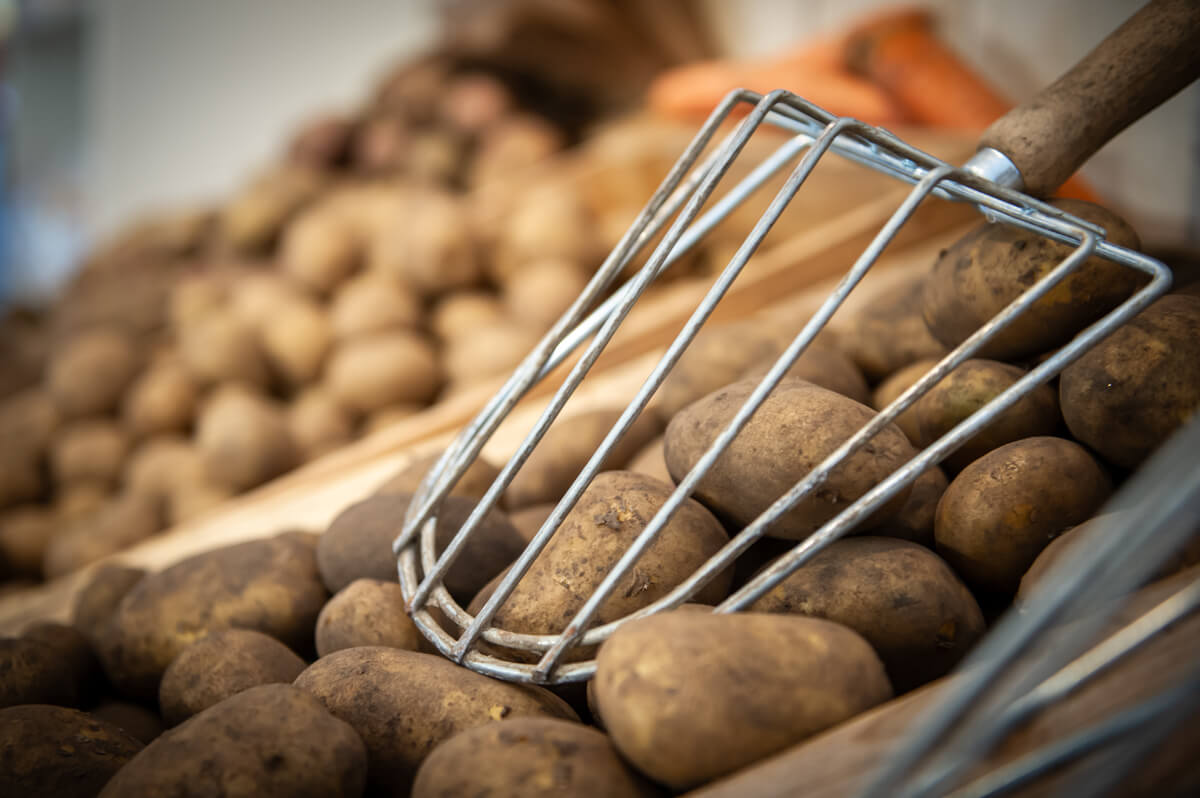 Potatis i lösvikt och en skopa att plocka dom med.